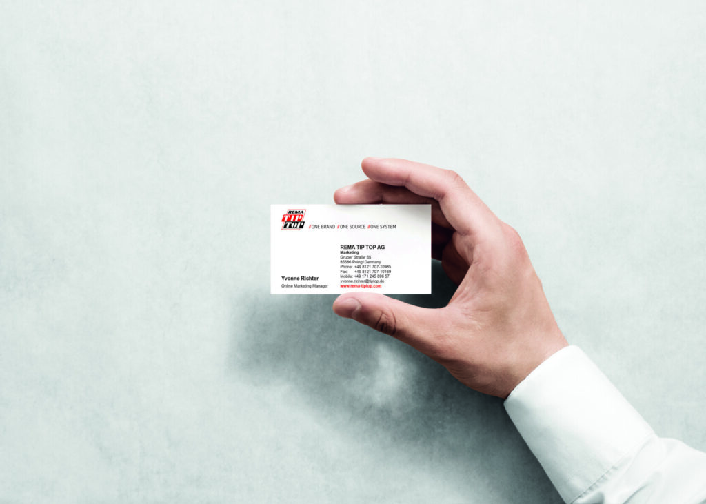Eine Person hält eine Visitenkarte in der Hand.