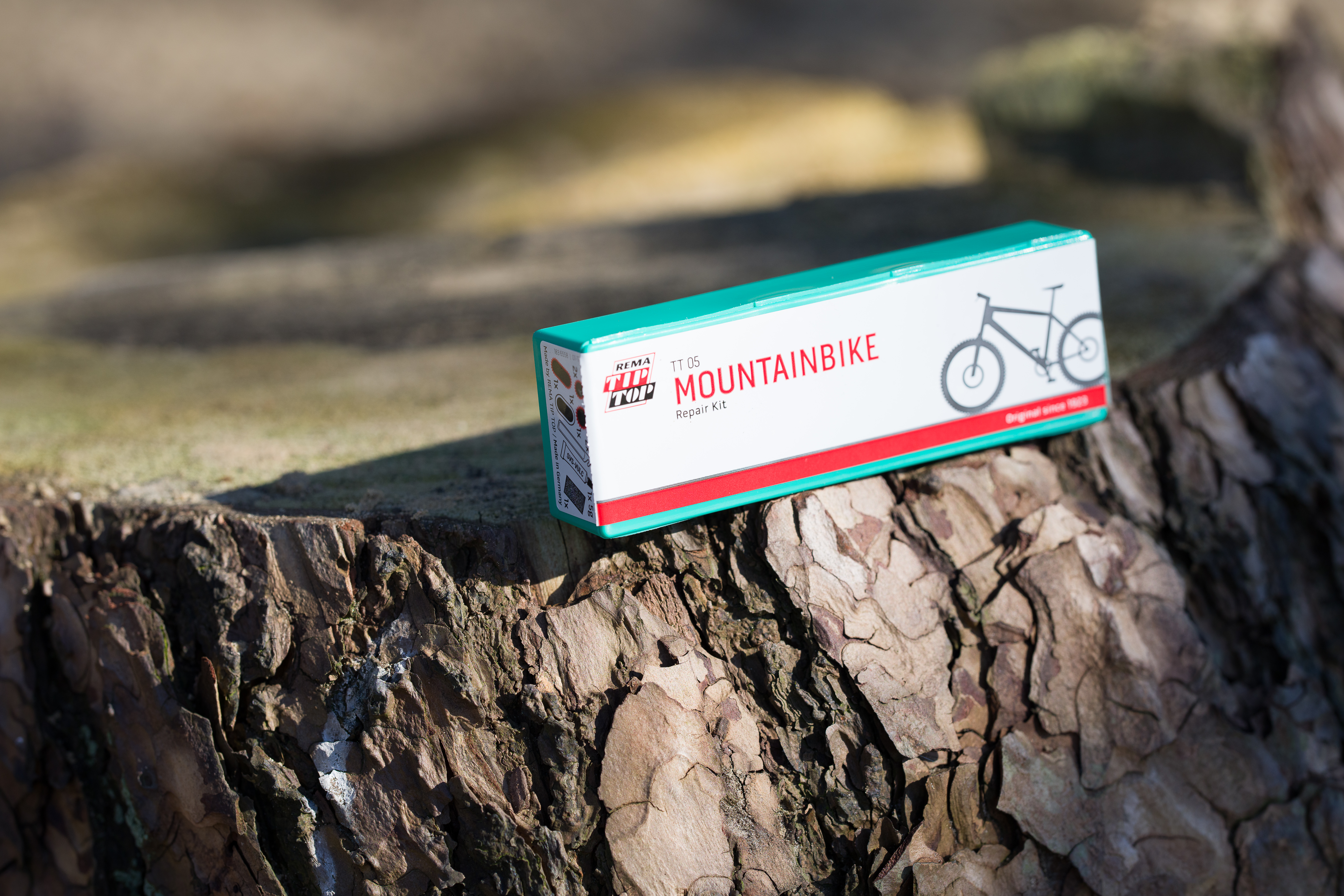Reparaturset für Mountainbikes auf einem Baumstamm