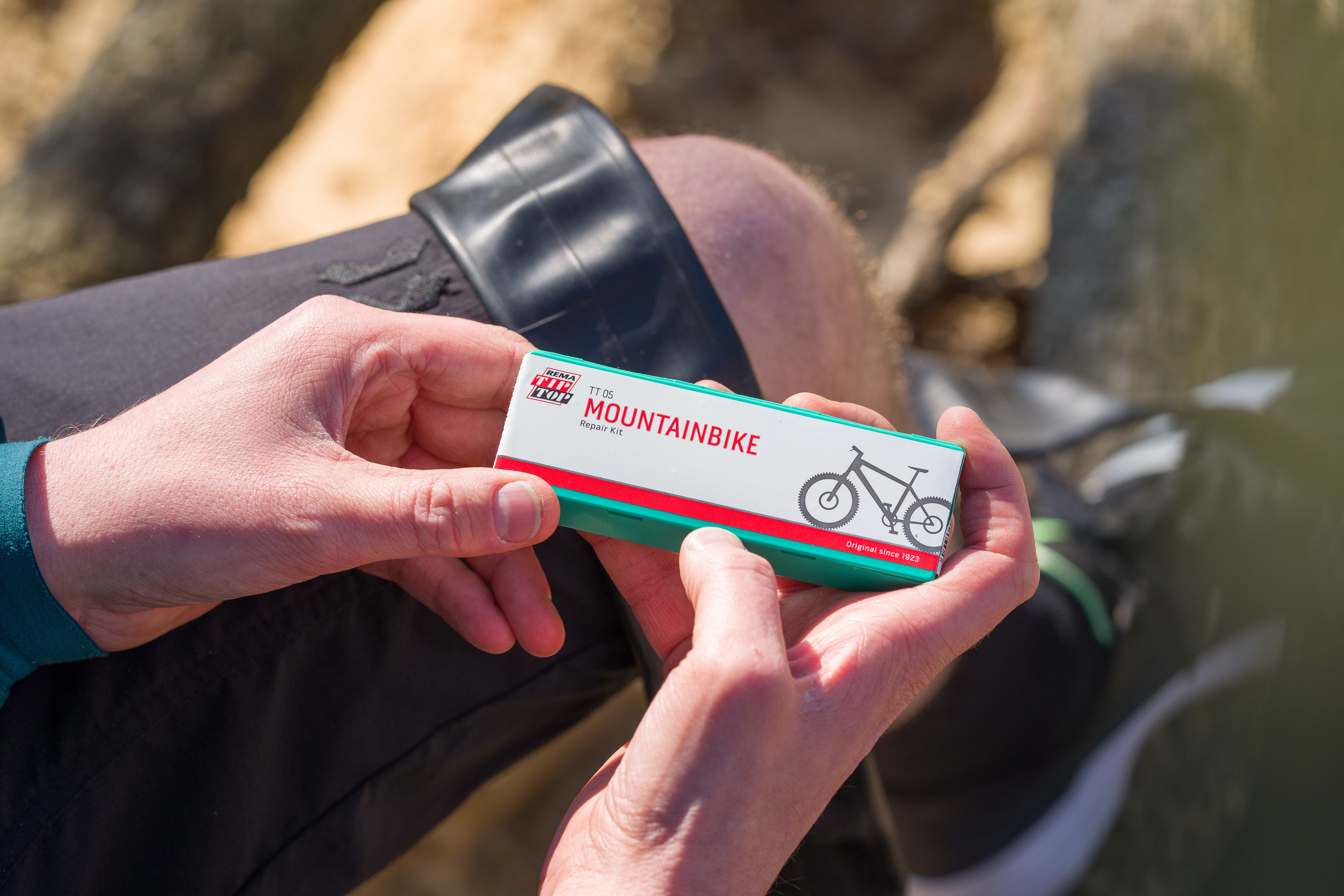 Eine Person hält ein Reparaturset für Mountainbikes in den Händen