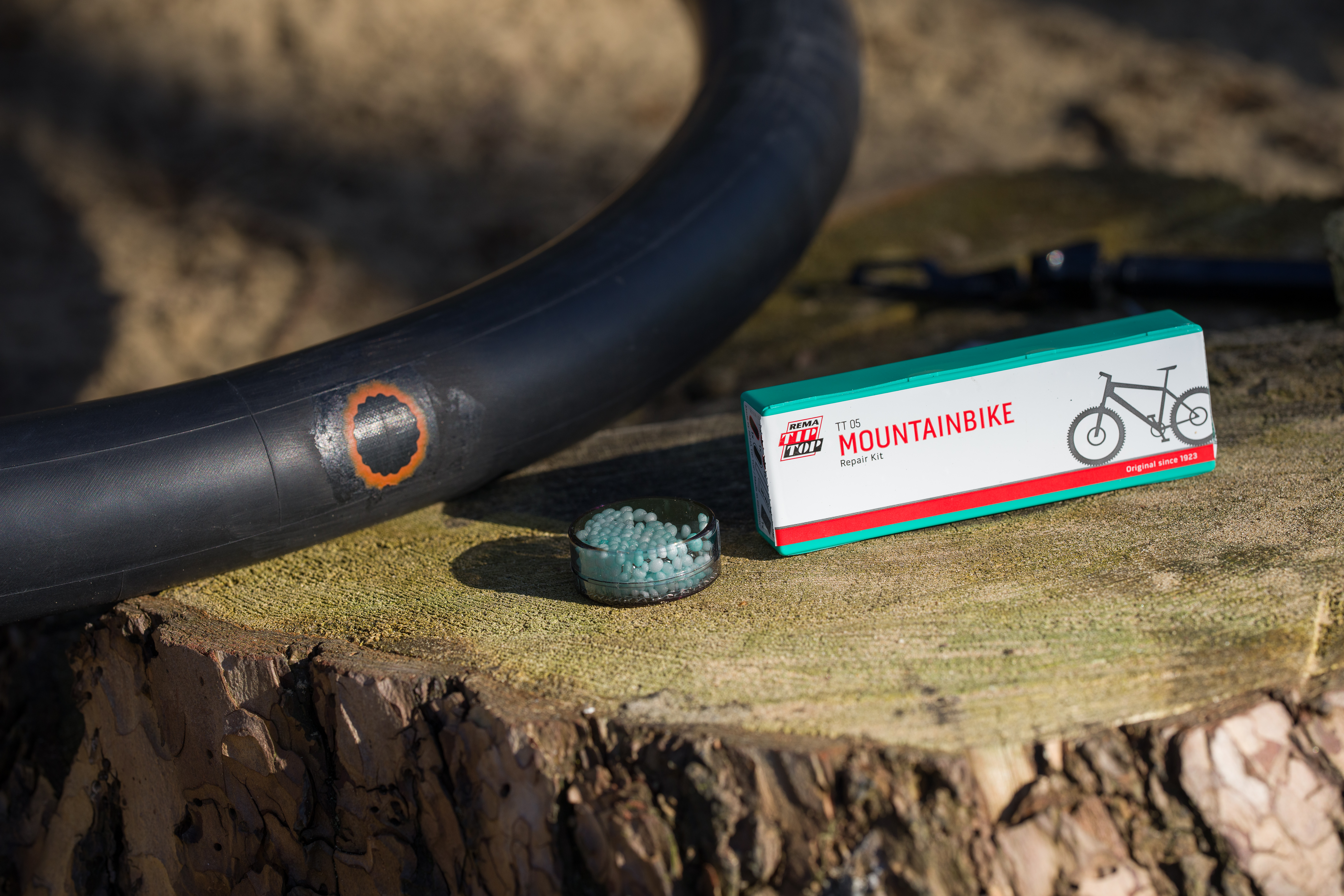 Ein Mountainbike-Reparaturset auf einem Baumstumpf.